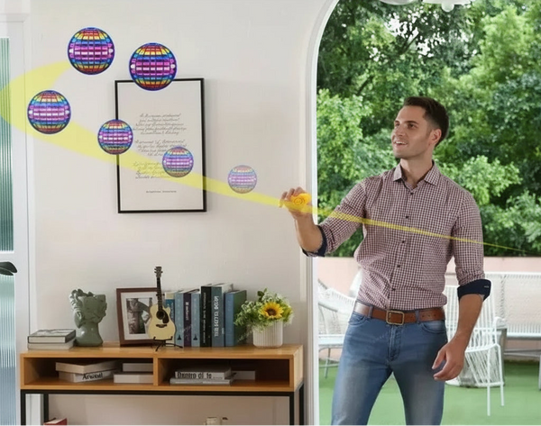 Man using a device to throw out a colorful ball, which returns automatically, in an outdoor setting.